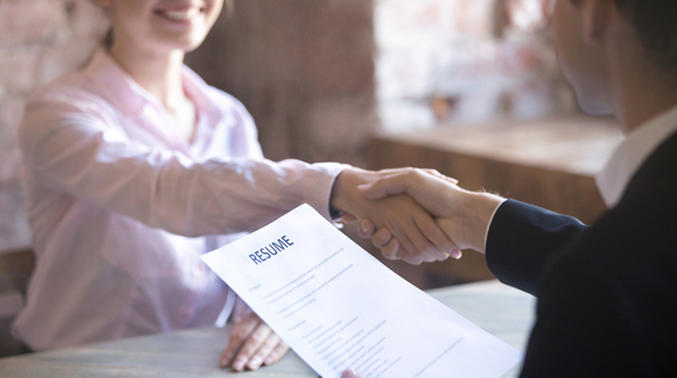 A job candidate shakes hands with an interviewing employer.